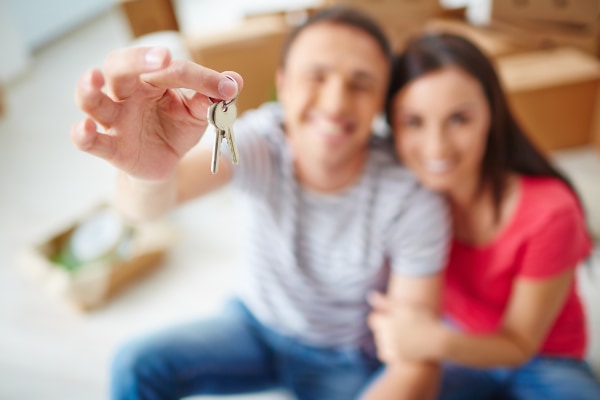 Pareja enseñando llaves de casa